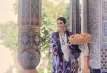 Saodat Tursunova presenting traditional Uzbek bread in an Uzbek cultural setting