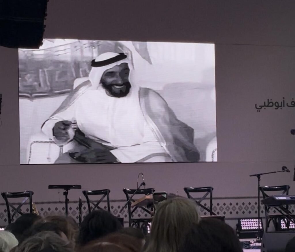 a large screen displays archival footage from the founding of the UAE period